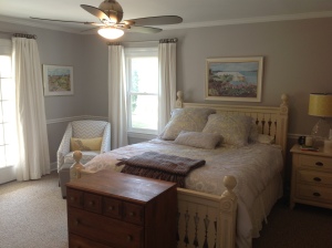 Updated bedroom with new chair, curtains, walls, ceiling, fan, and bedding.